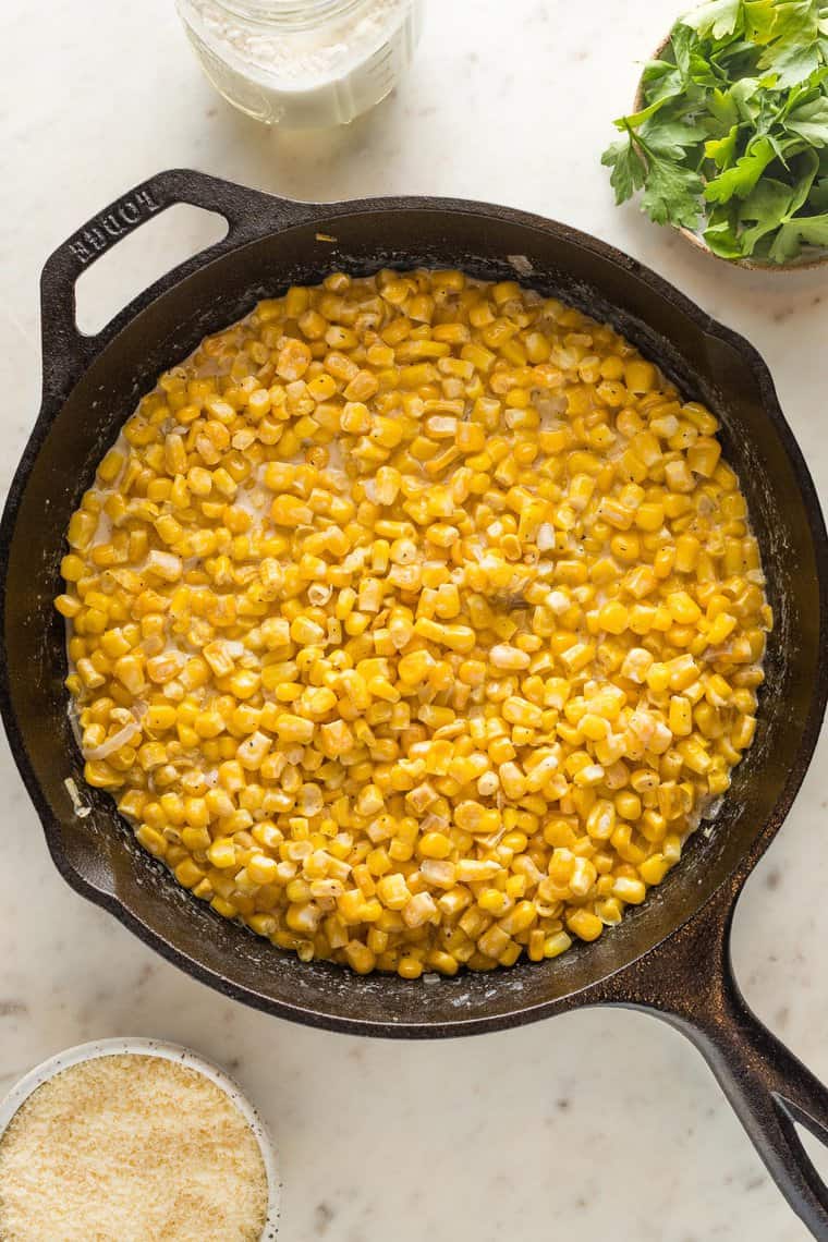 Fresh corn being cooked in a cast iron skillet