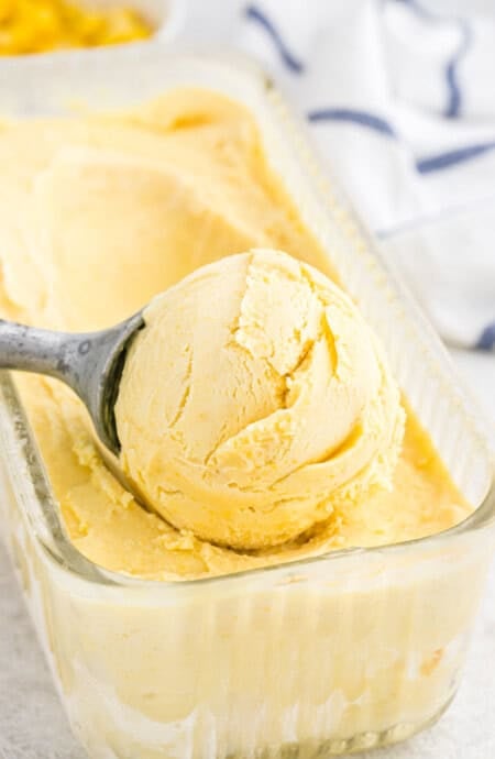 A large scoop of corn ice cream ready to serve on a white background