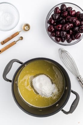 cornstarch in an orange butter sauce to thicken in a pot