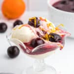 A glass of ice cream with a cherries jubilee ready to serve