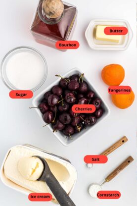 Cherries in a crate, vanilla ice cream, and bowls of ingredients for a recipe