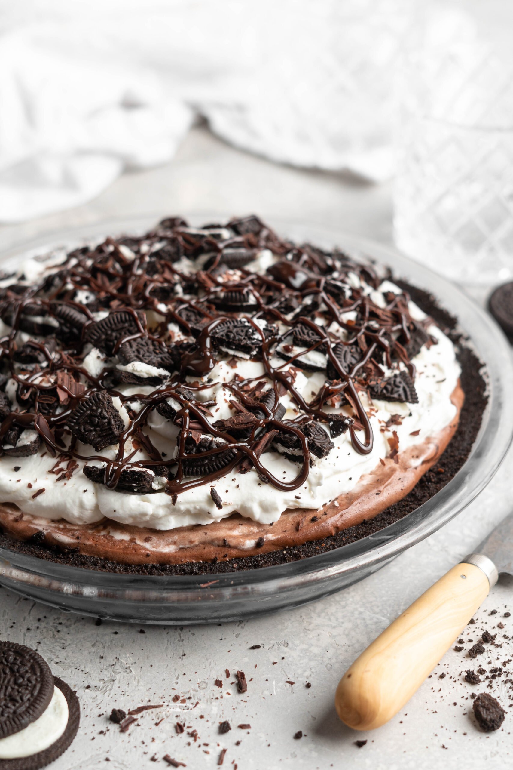 A Mississsippi mud pie with oreo cookies and chocolate sauce on top ready to serve