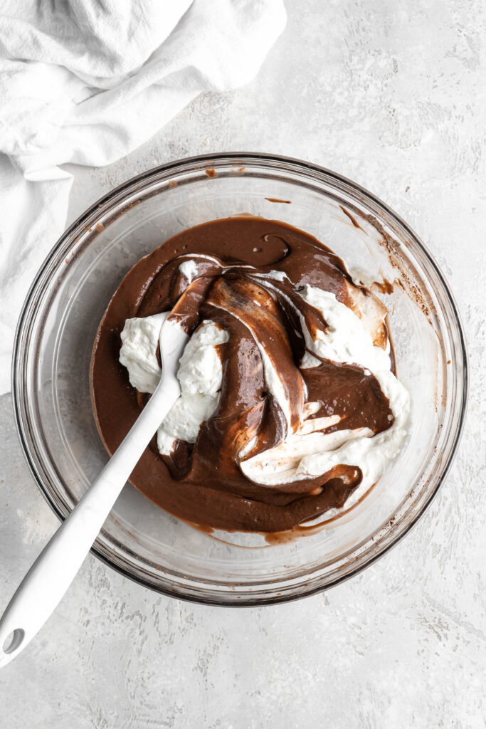 Whipped cream being folded into chocolate pudding