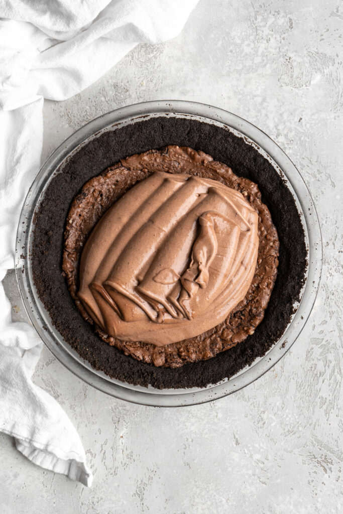 A chocolate pudding spread on top of a brownie layer