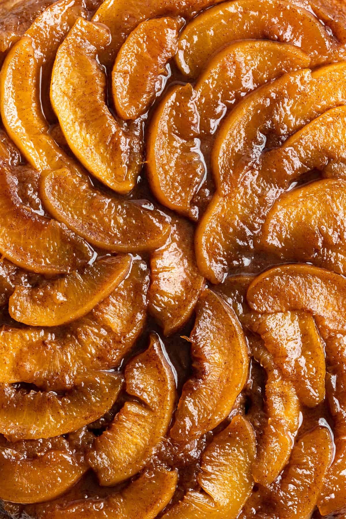 A close up of decorative peaches caramelized on a cake