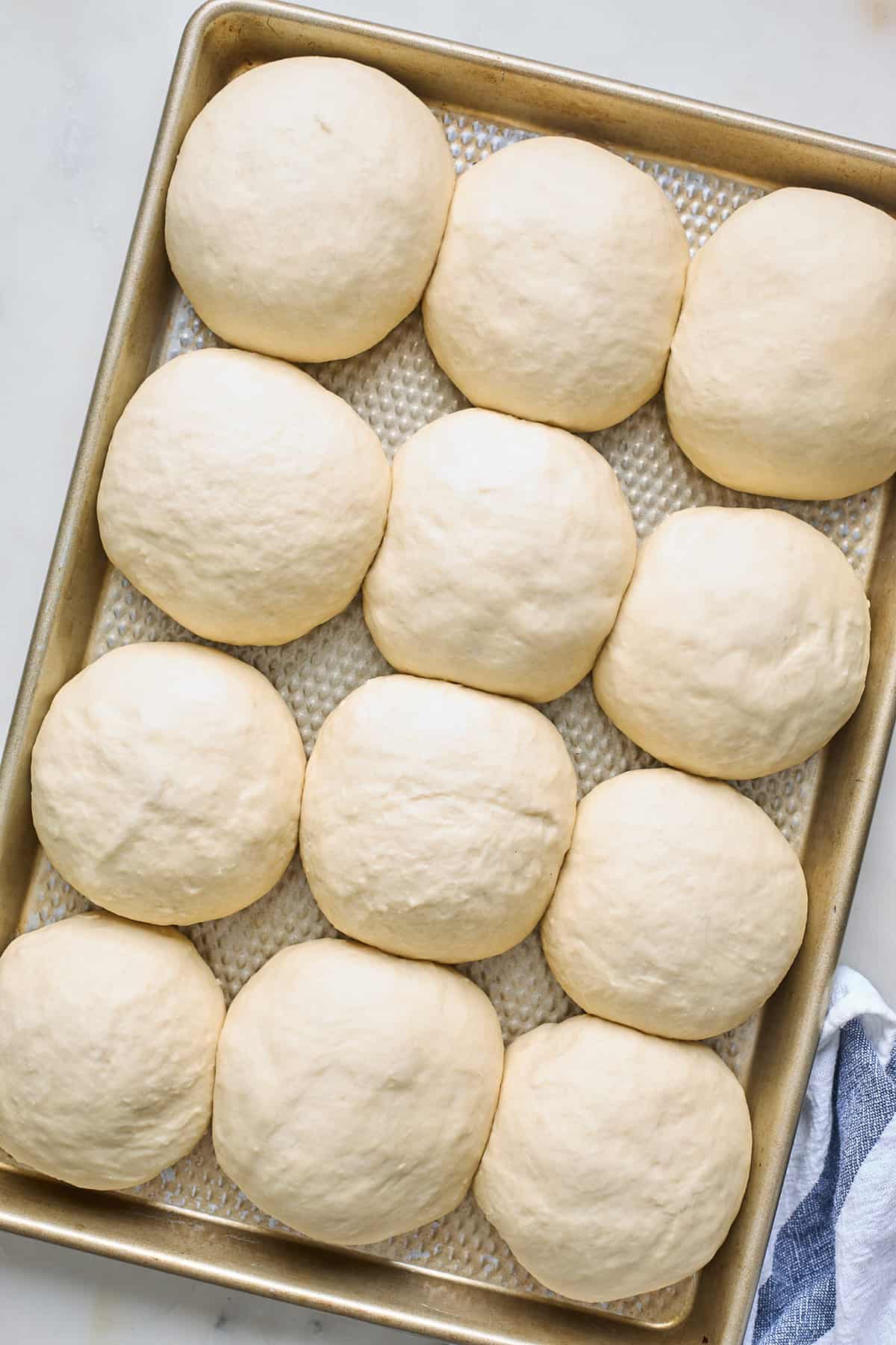 Dough balls are risen and added to a baking pan