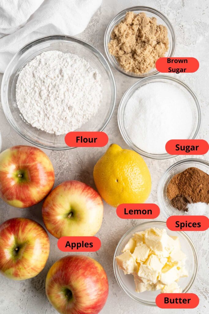 Whole apples, a lemon, flour, sugar and brown sugar in separate bowls