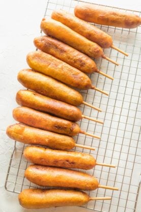 Corn dogs arranged on a wire rack
