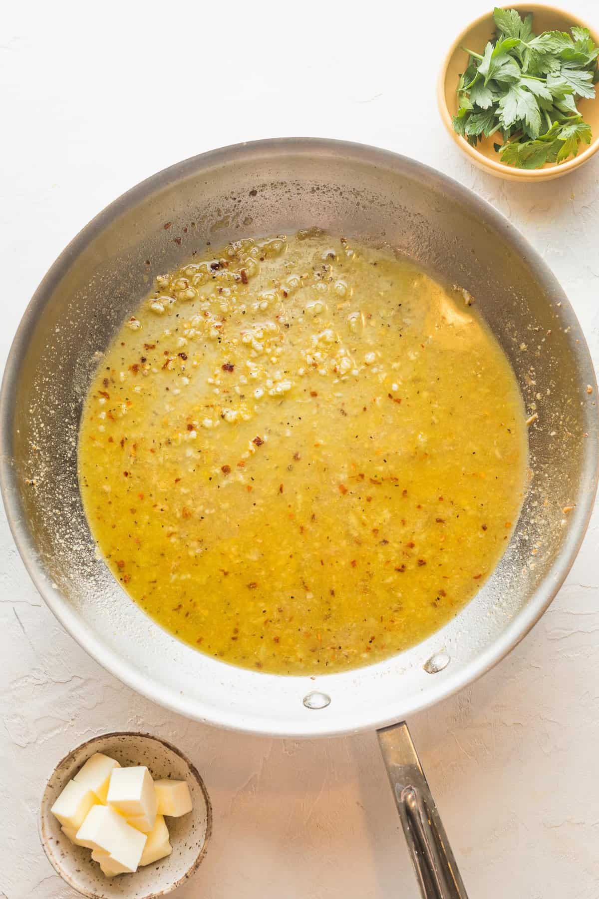 A lemon garlic sauce simmering in a skillet
