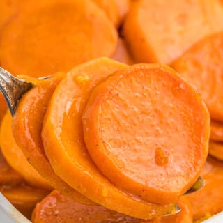 A serving fork with a scoop of baked candied yams.