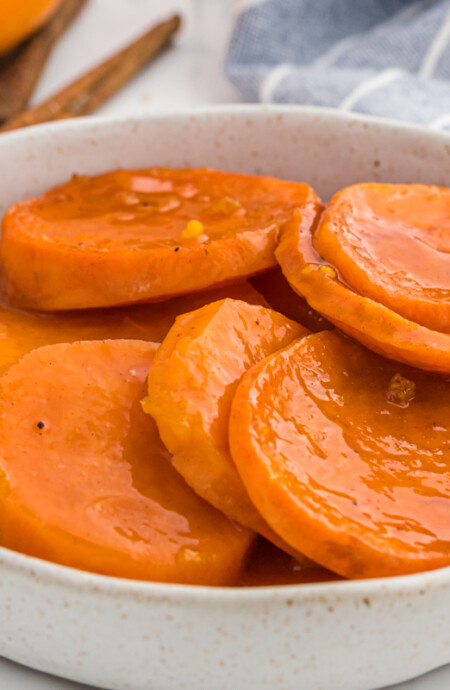 A small white bowl with a serving of candied yams.