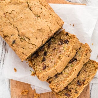 A loaf of chocolate chip zucchini bread with slices on one end.