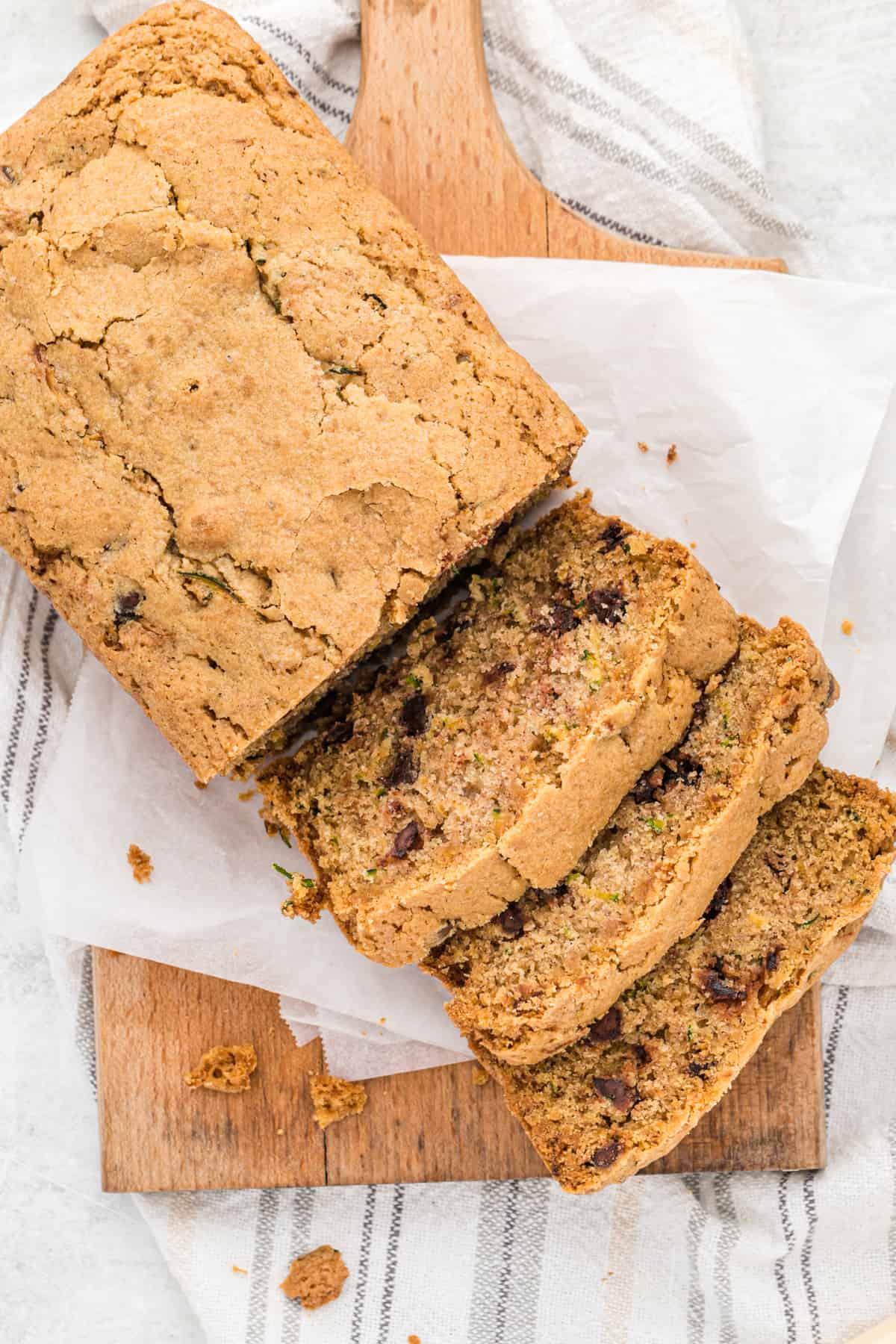 A loaf of chocolate chip zucchini bread with slices on one end.