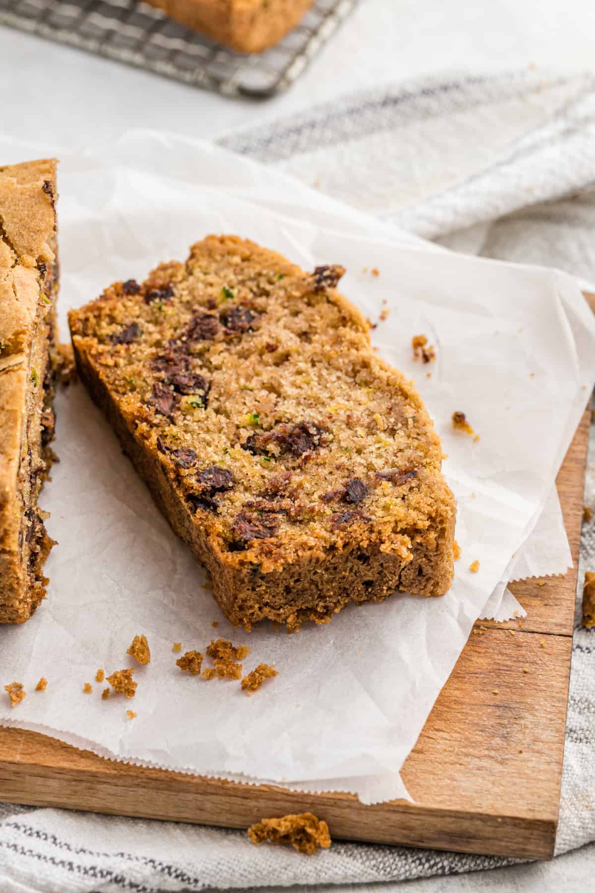 A single slice of chocolate chip zucchini bread on parchment paper.