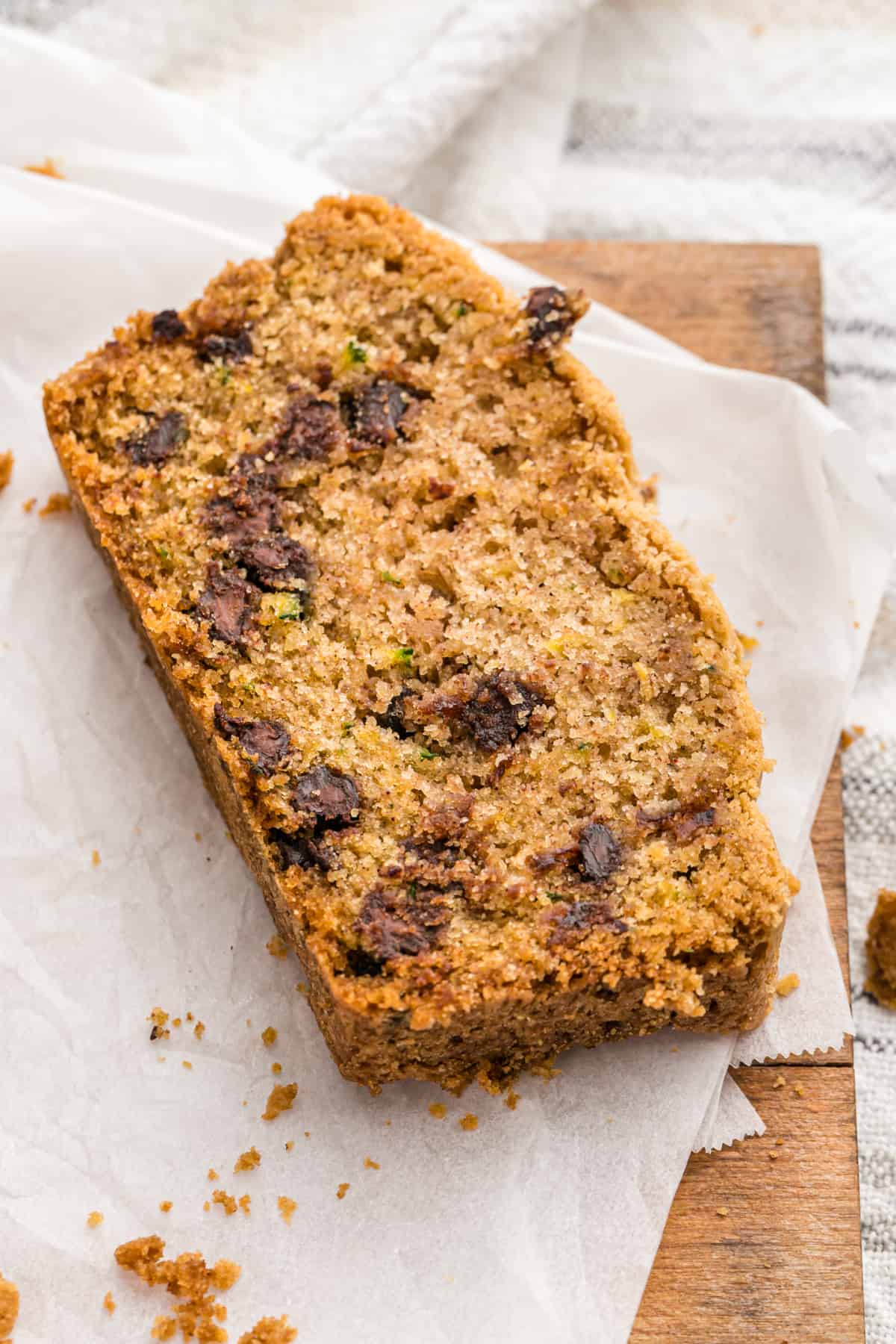 A single slice of chocolate chip zucchini bread on parchment paper.