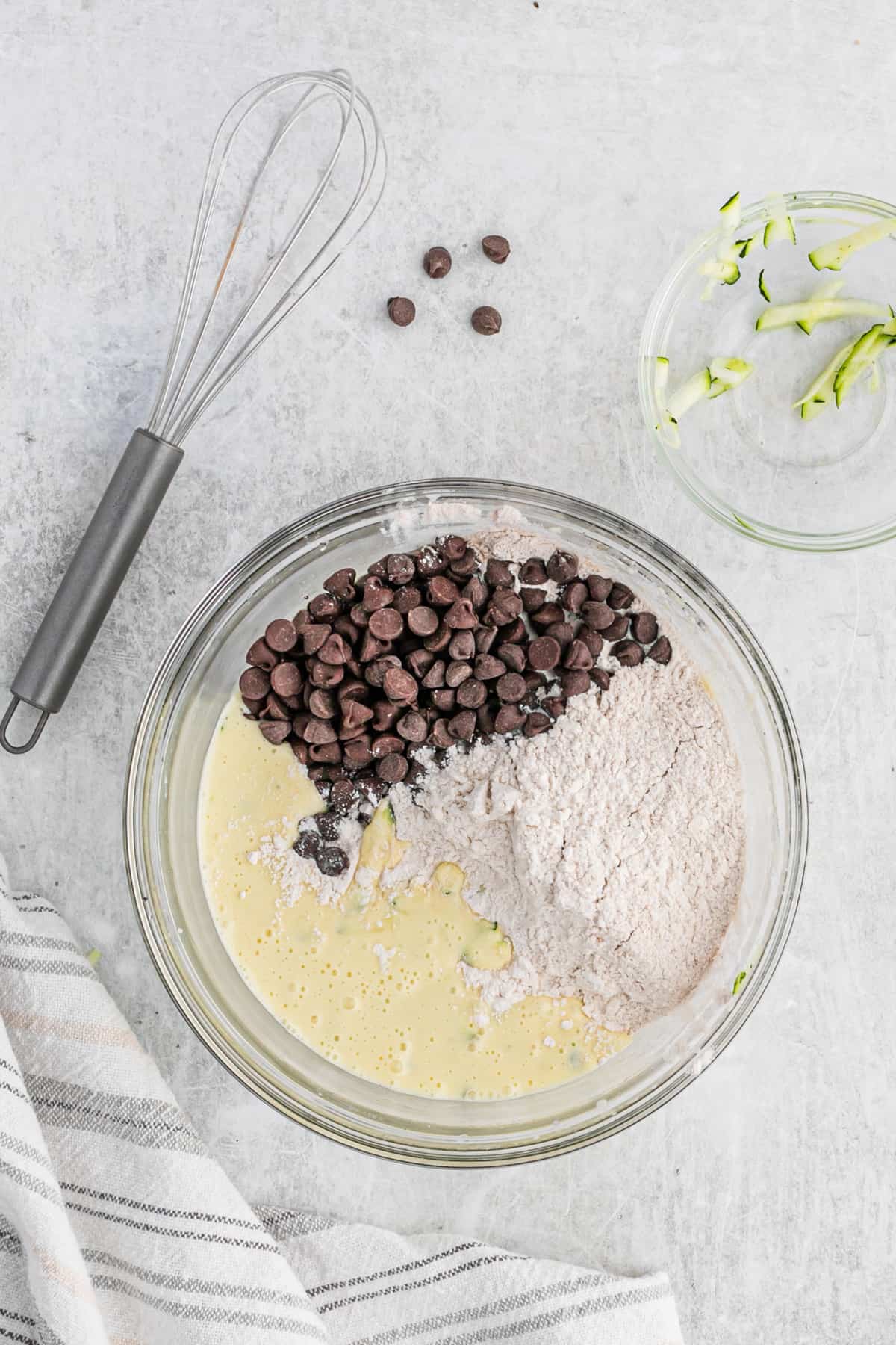 Ingredients for zucchini bread in a glass mixing bowl.