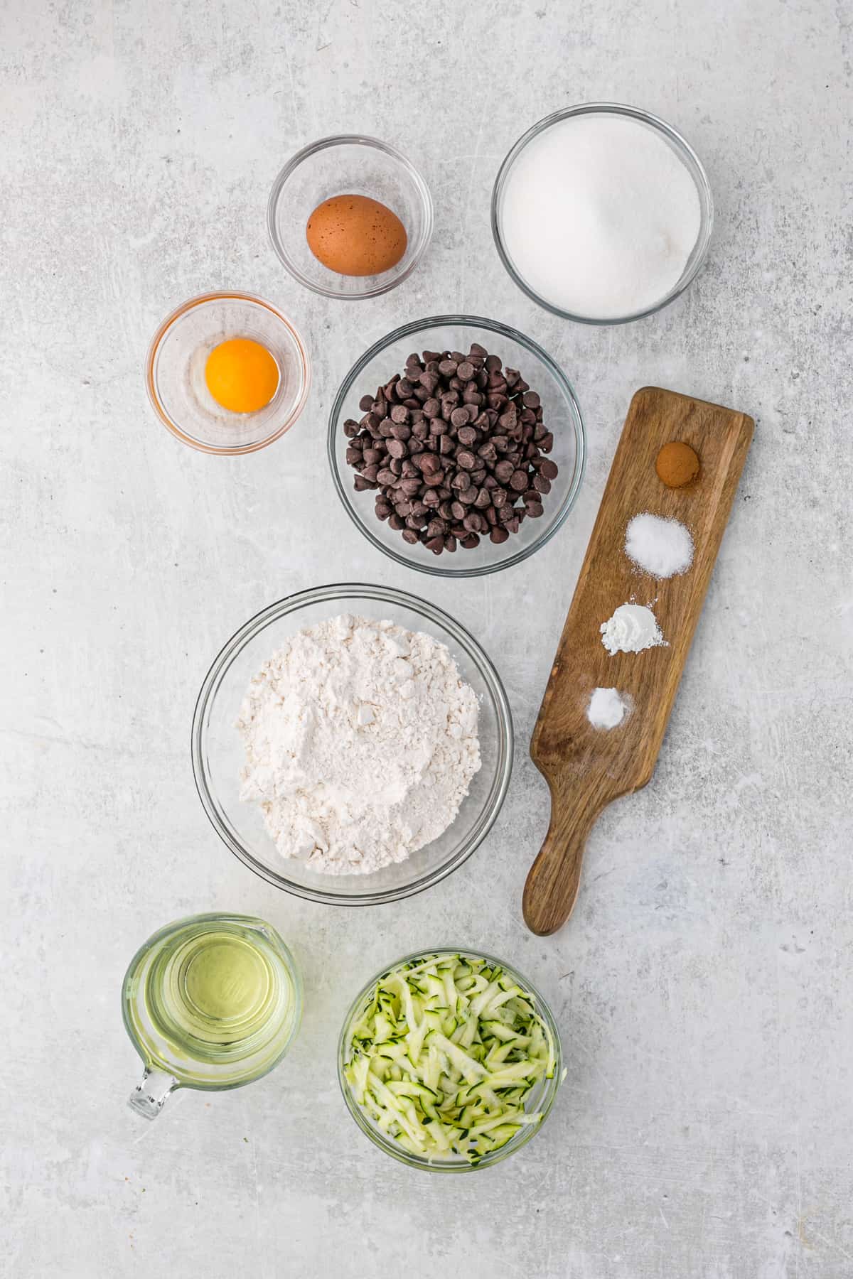 Ingredients to make chocolate chip zucchini bread set in small bowls.