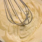 A whisk in a cast iron skillet of finished roux.