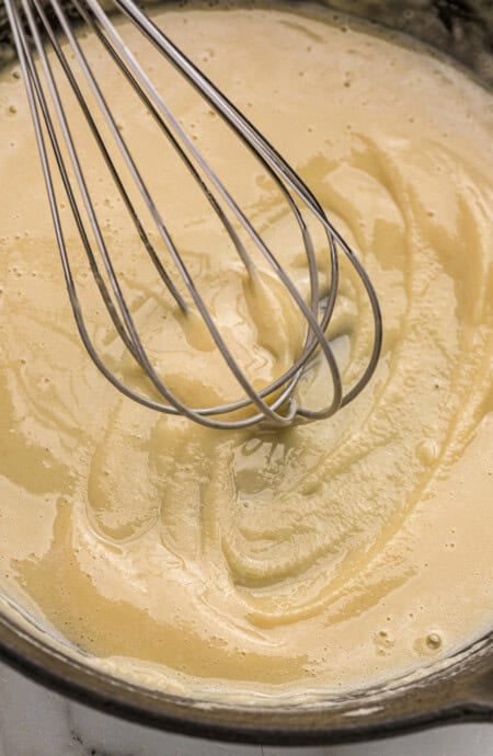 A whisk in a cast iron skillet of finished roux.