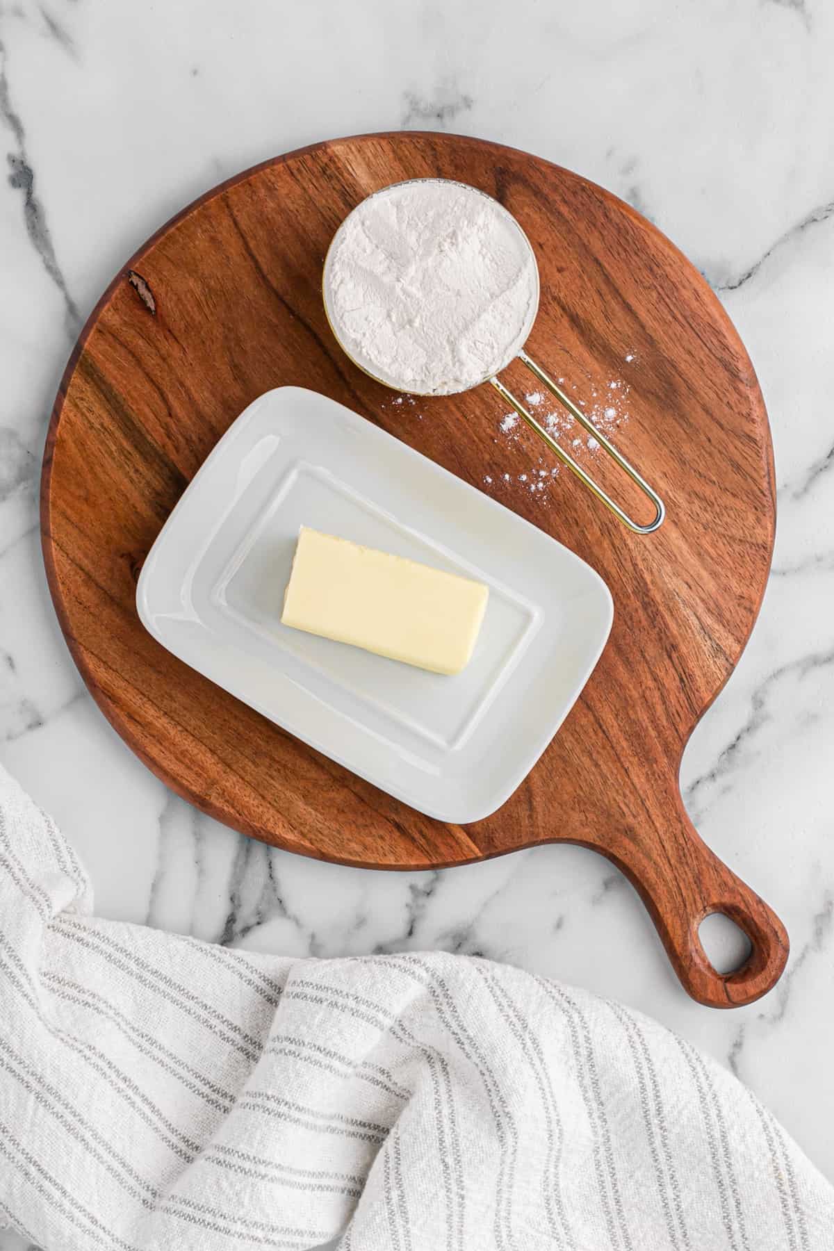 Butter and flour on a wooden board.