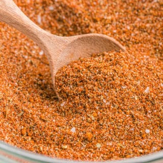 A wooden spoon in a mixing bowl of homemade turkey rub.