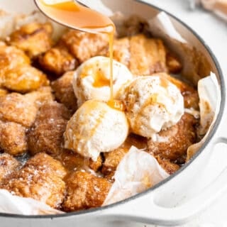 A delicious shot of apple dumplings with sauce being poured on top