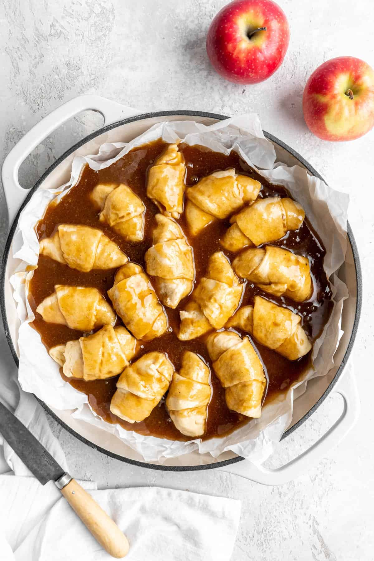 syrup poured over apple dumplings in the pan