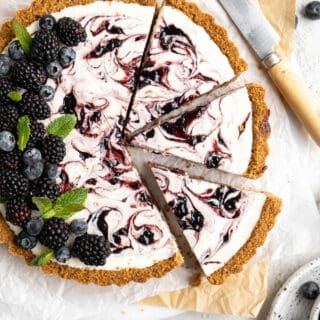 A close up of a blackberry lemonade pie with slices cut and ready to serve