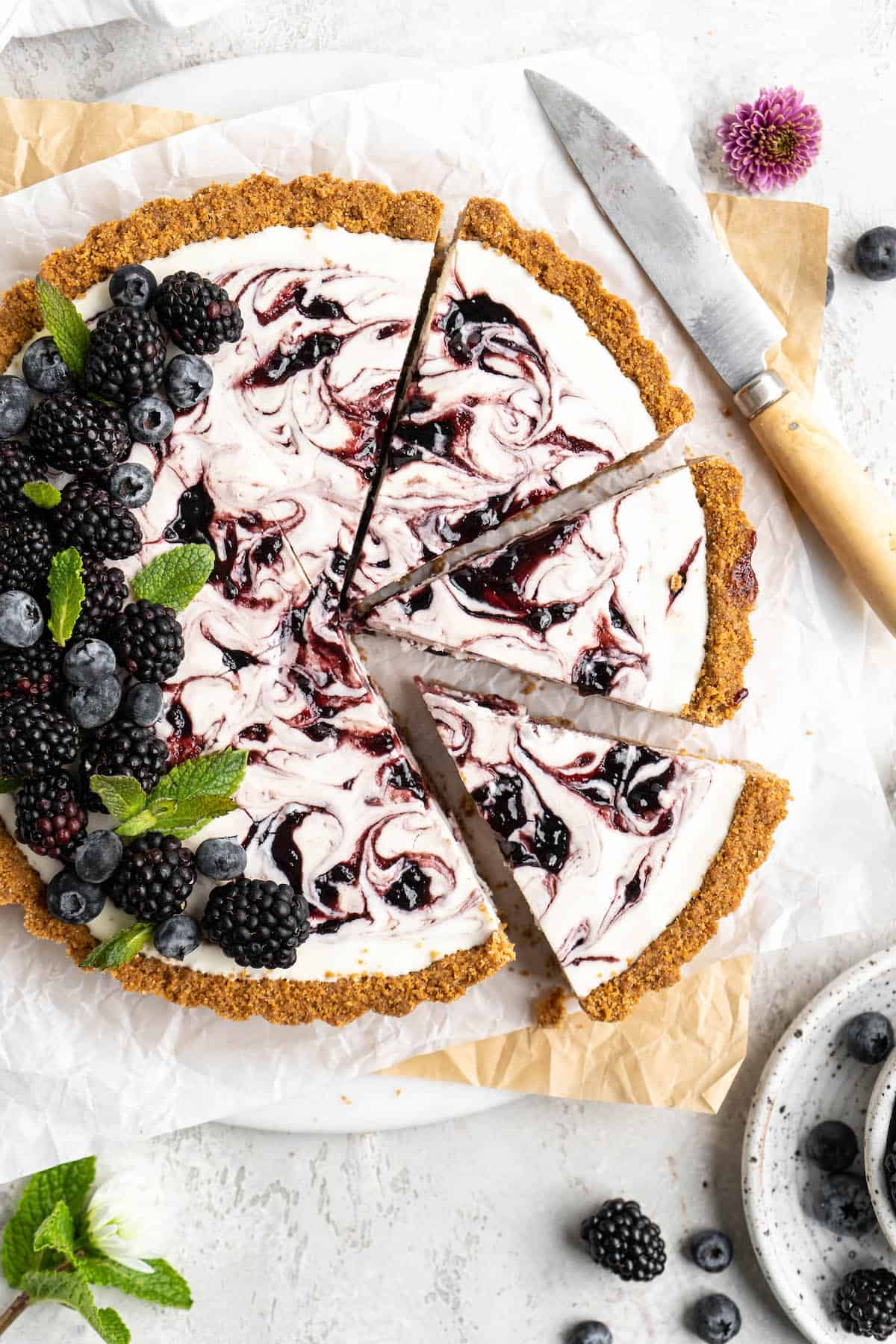 A close up of a blackberry lemonade pie with slices cut and ready to serve