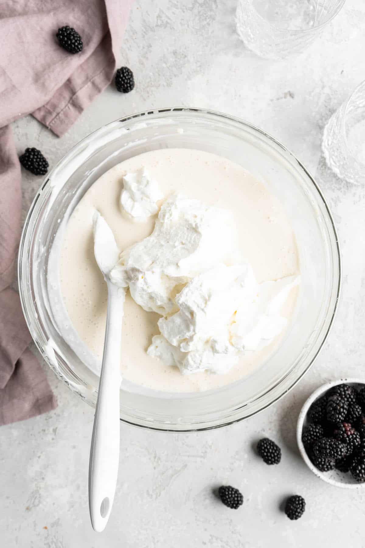 Whipped cream being folded into a cream cheese filling base