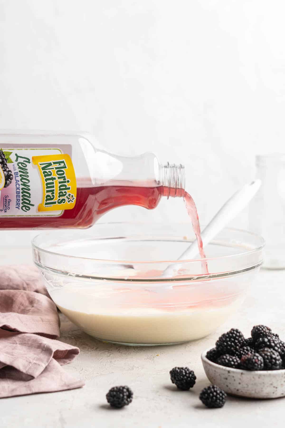 Blackberry lemonade being poured into a cream pie filling