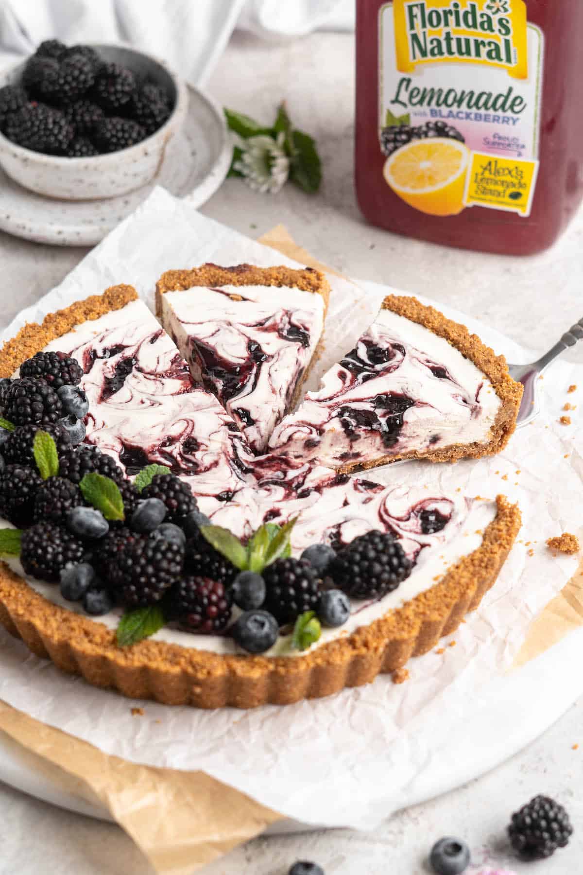 A slice of icebox pie being removed to serve with lemonade in the background