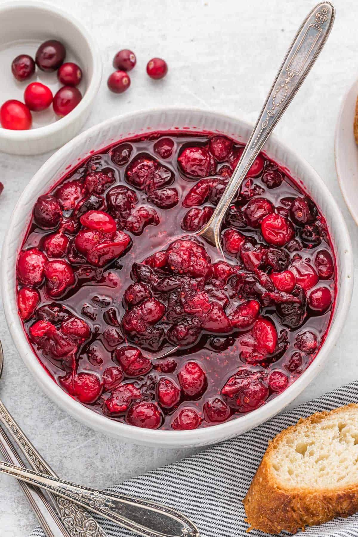 Bowl of cranberry sauce with a silver serving spoon.