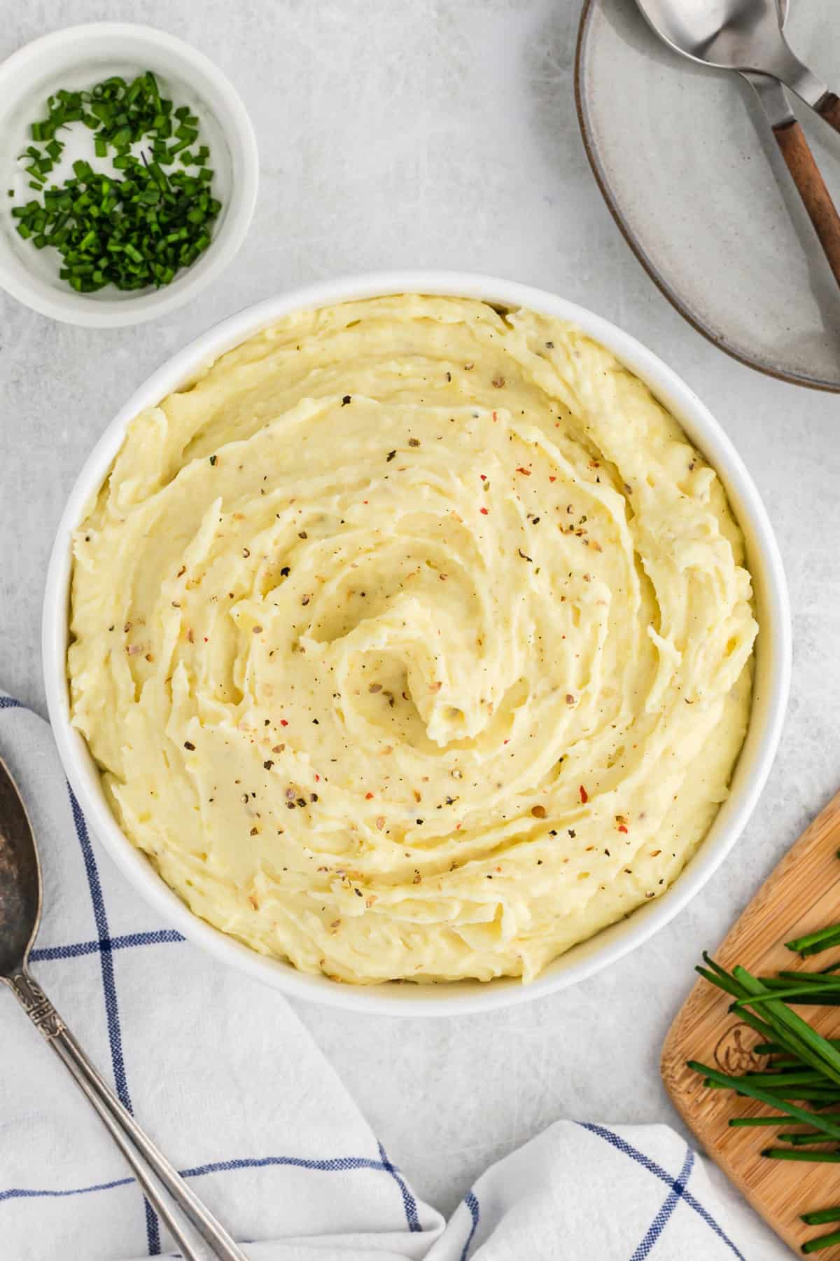 A large bowl of mashed potato recipe with sour cream on white background