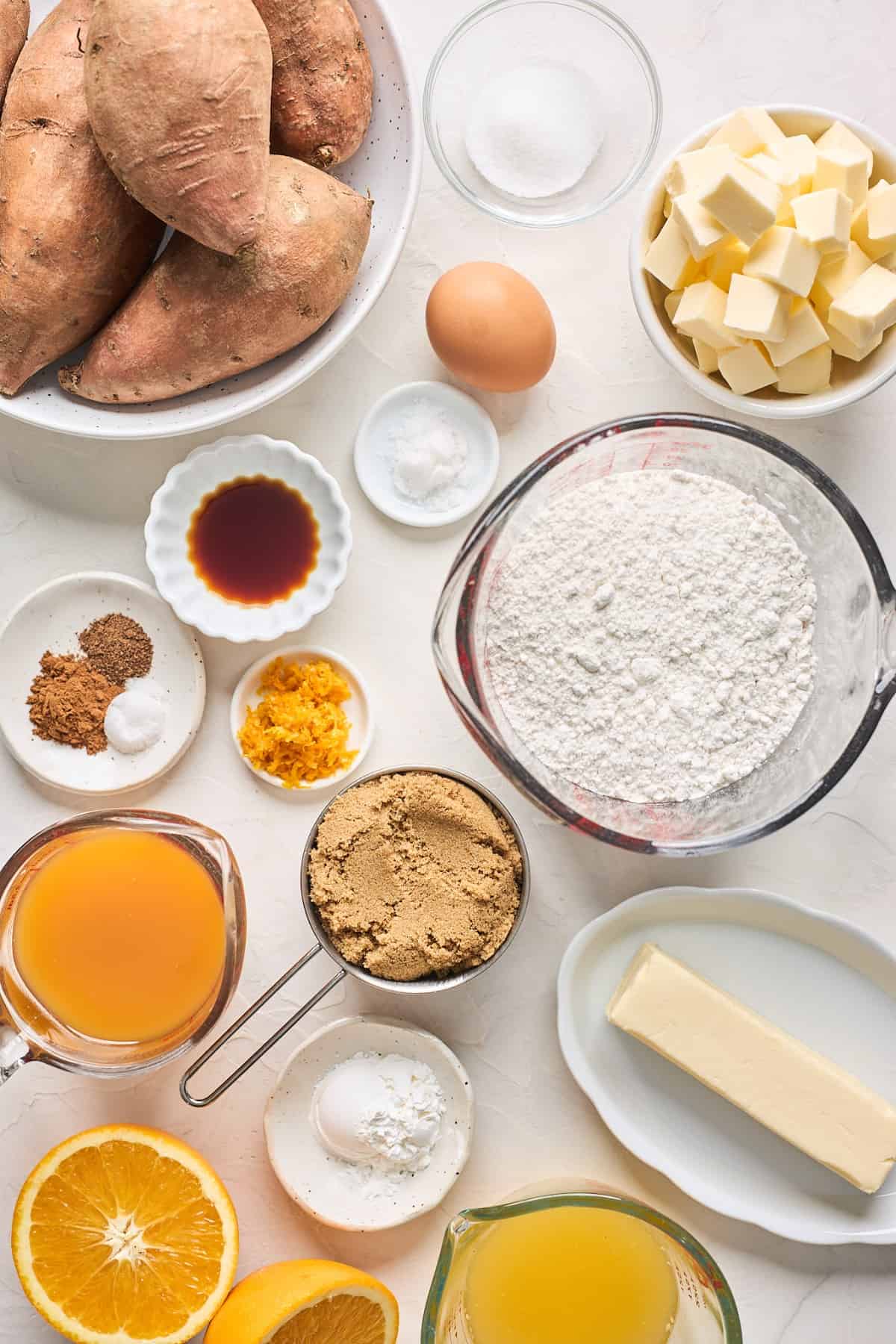 Ingredients to make sweet potato cobbler in small bowls on a white surface