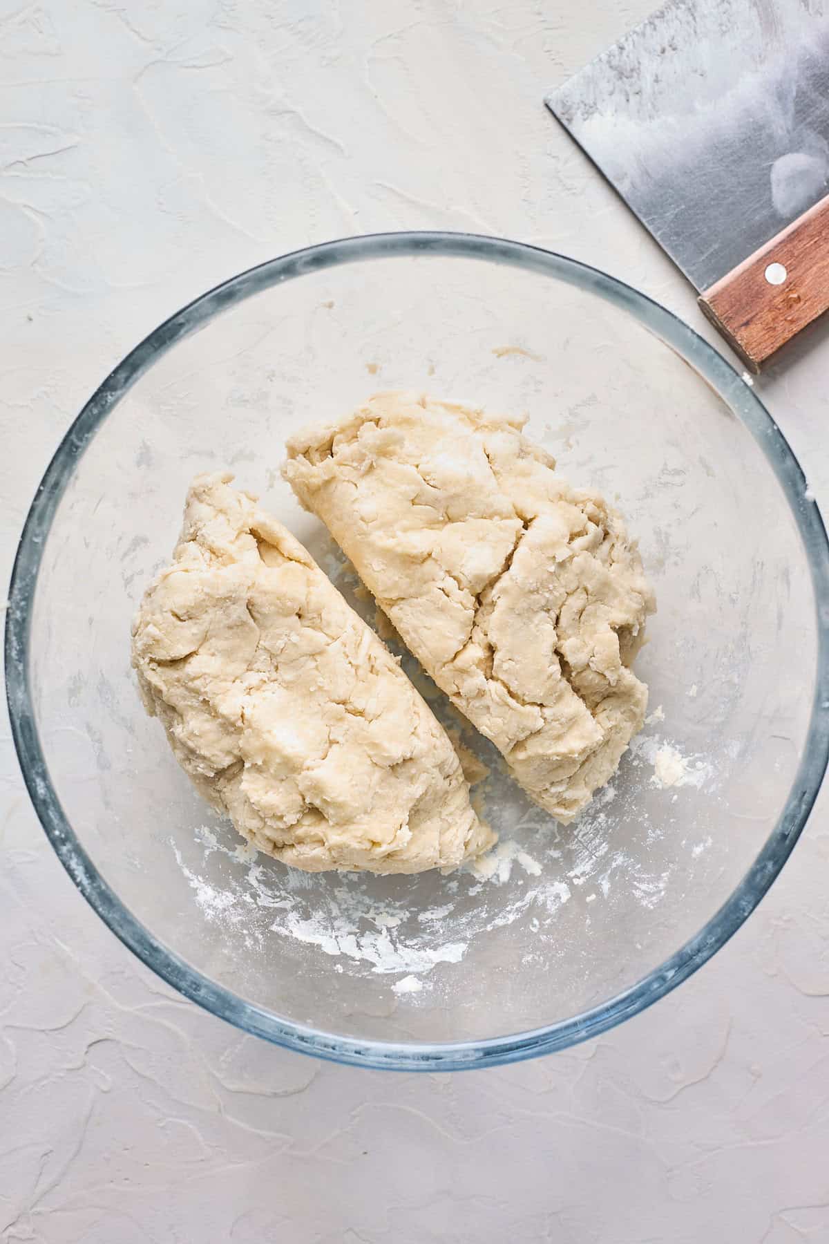 Pie dough cut in two sections inside of a glass bowl