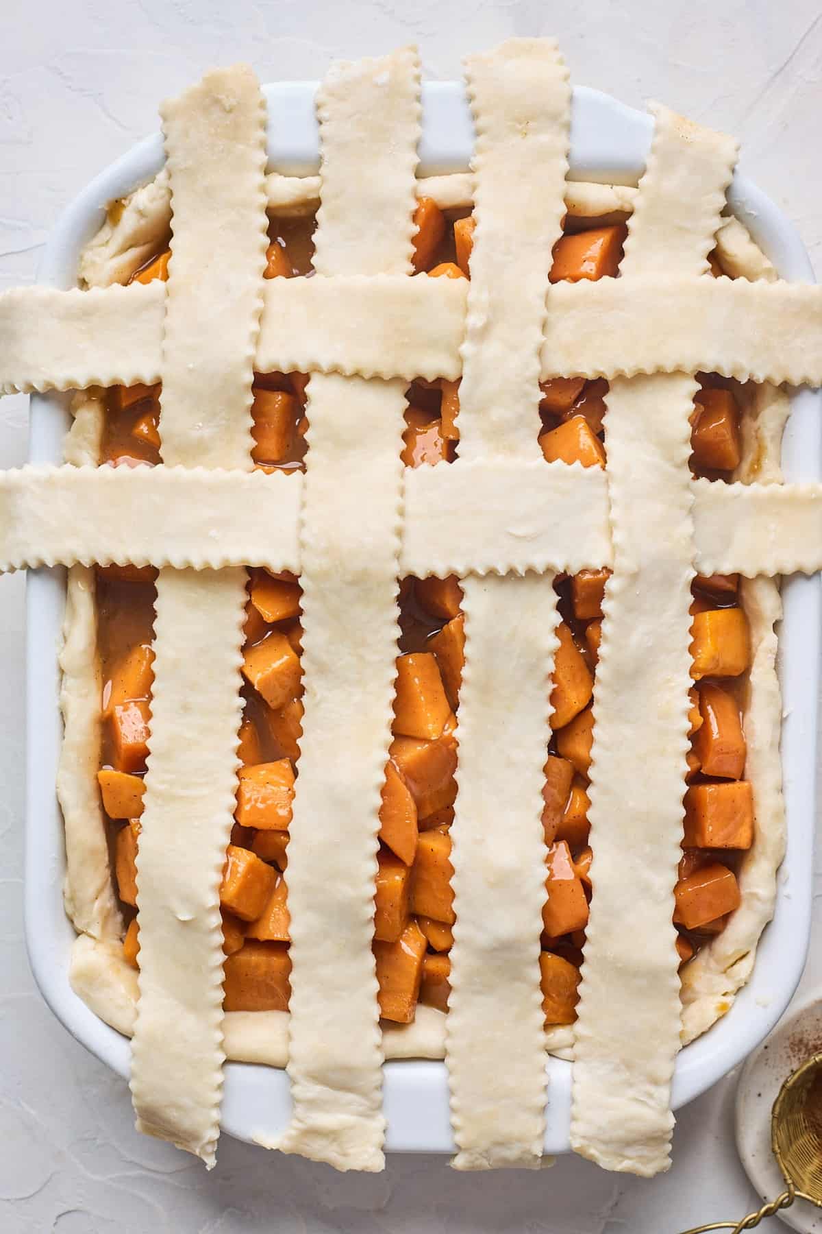 Assembling a lattice top crust on a sweet potato cobbler.
