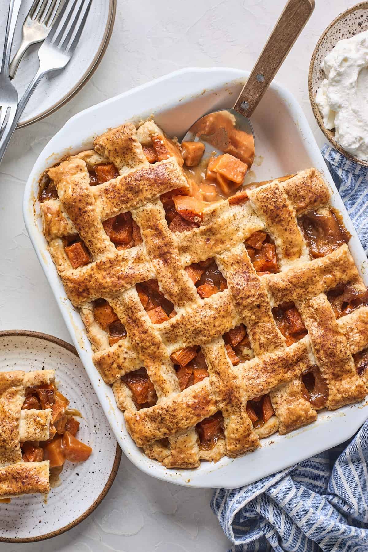 Rectangle baking dish of sweet potato cobbler with a corner slice removed.