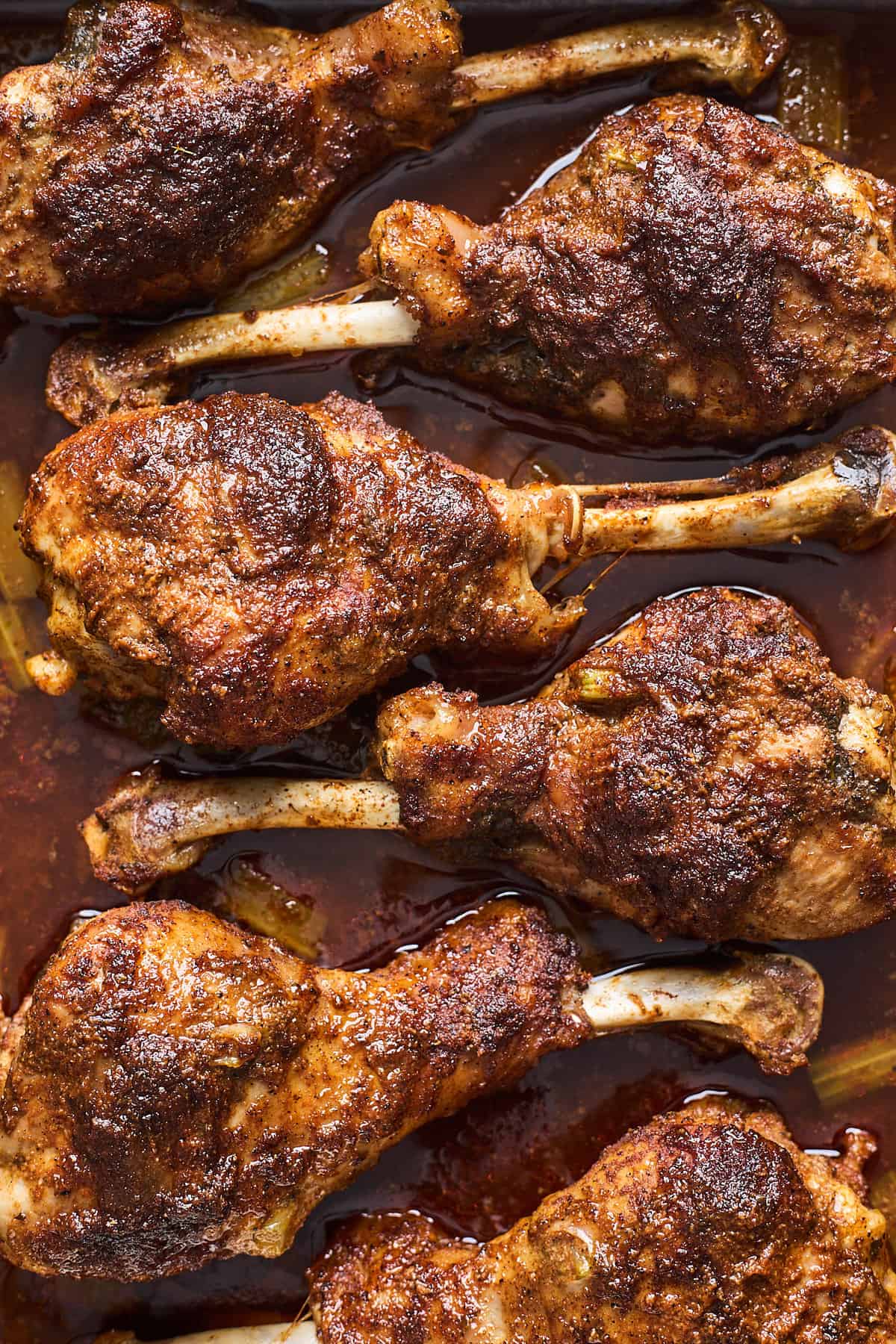 Oven baked turkey legs close up in a pan