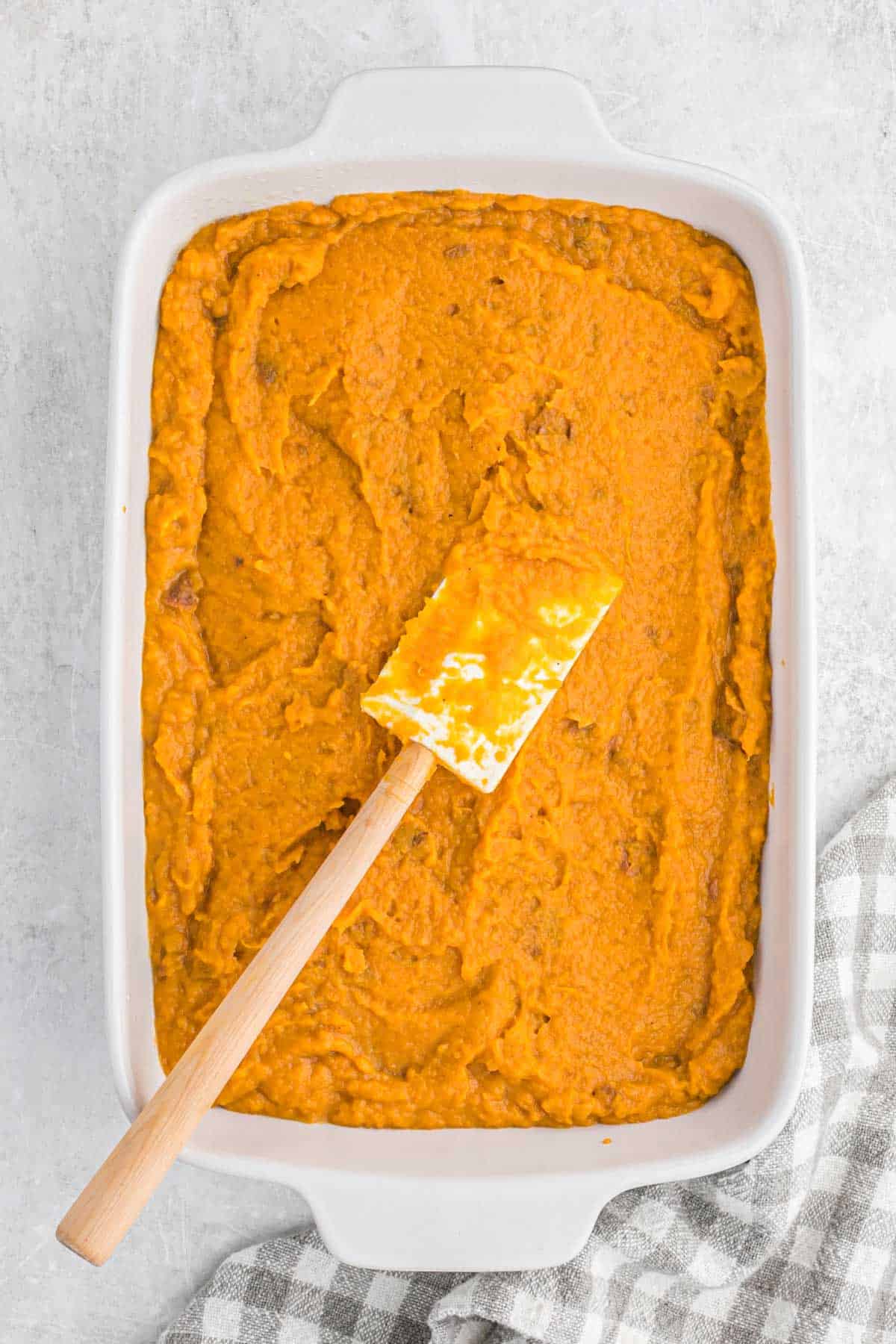 Mashed sweet potatoes spread into the casserole dish.