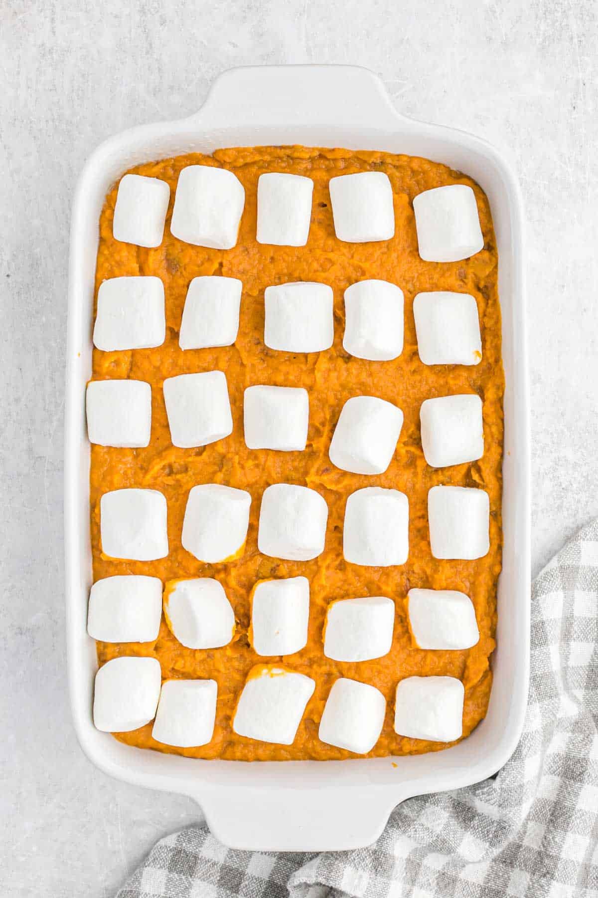 Sweet potato casserole in the dish with marshmallows on top.