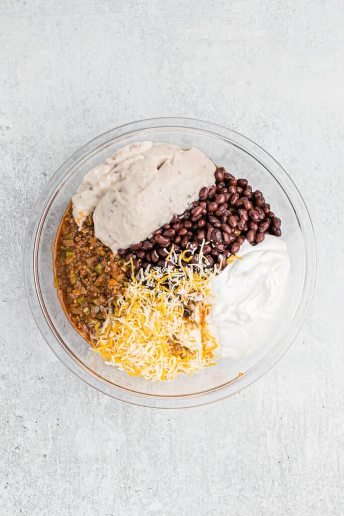 Black beans, sour cream and cheeses in a clear bowl