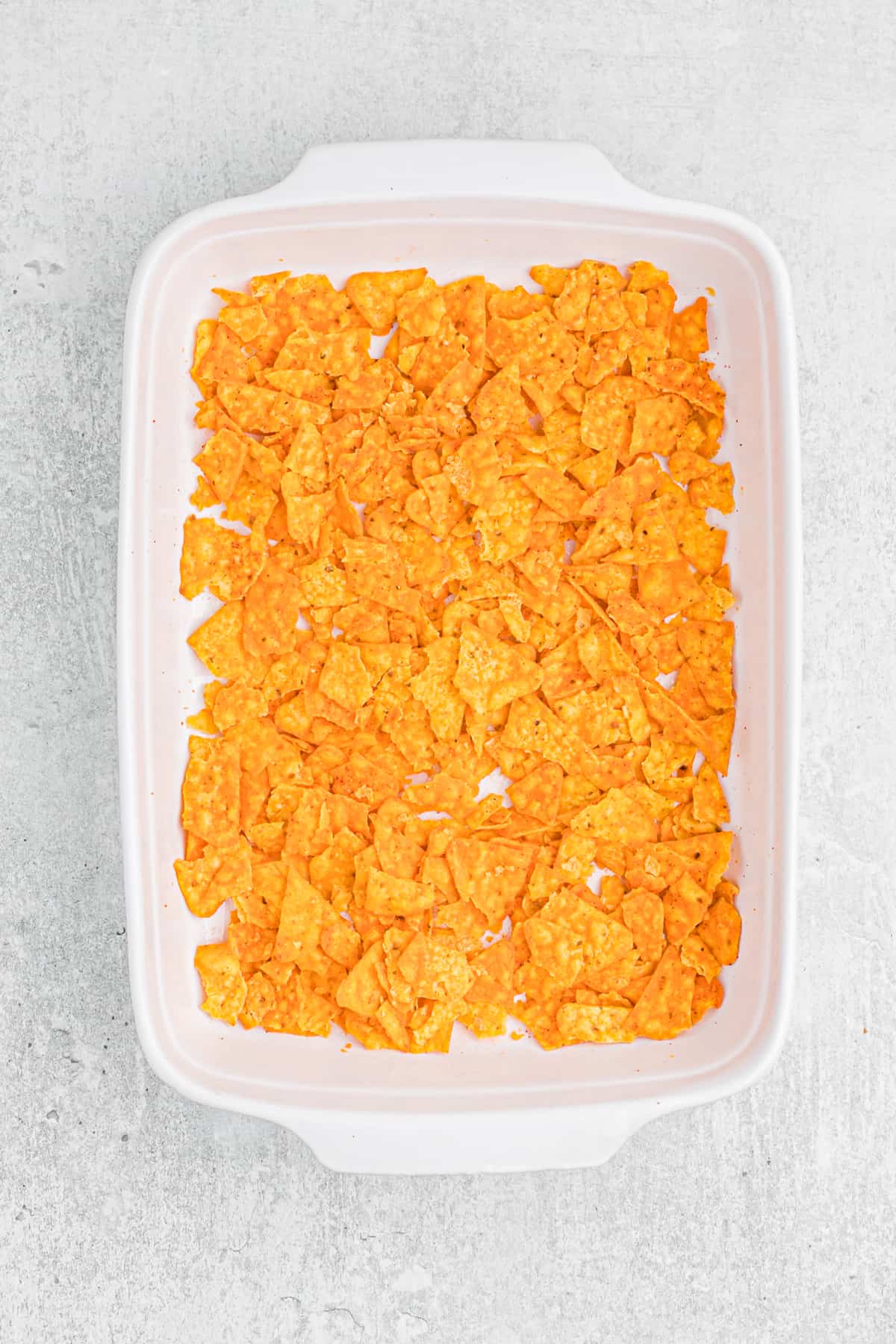 Crushed doritos in a casserole dish