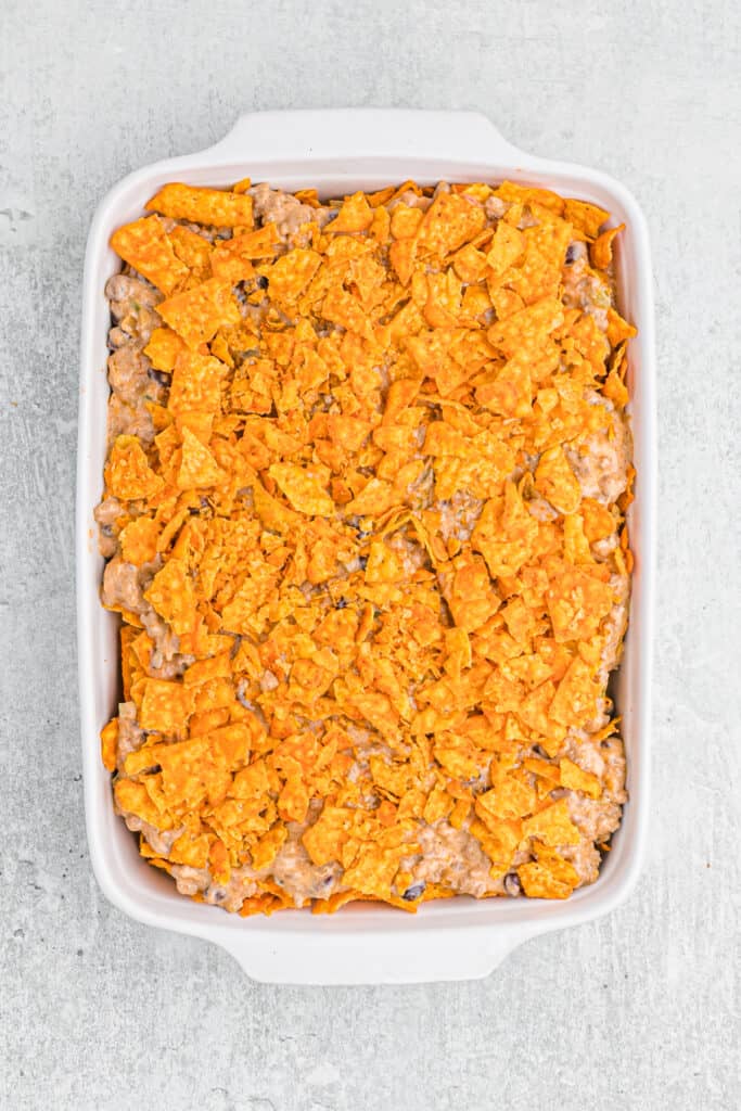 A casserole with crushed doritos on top before baking