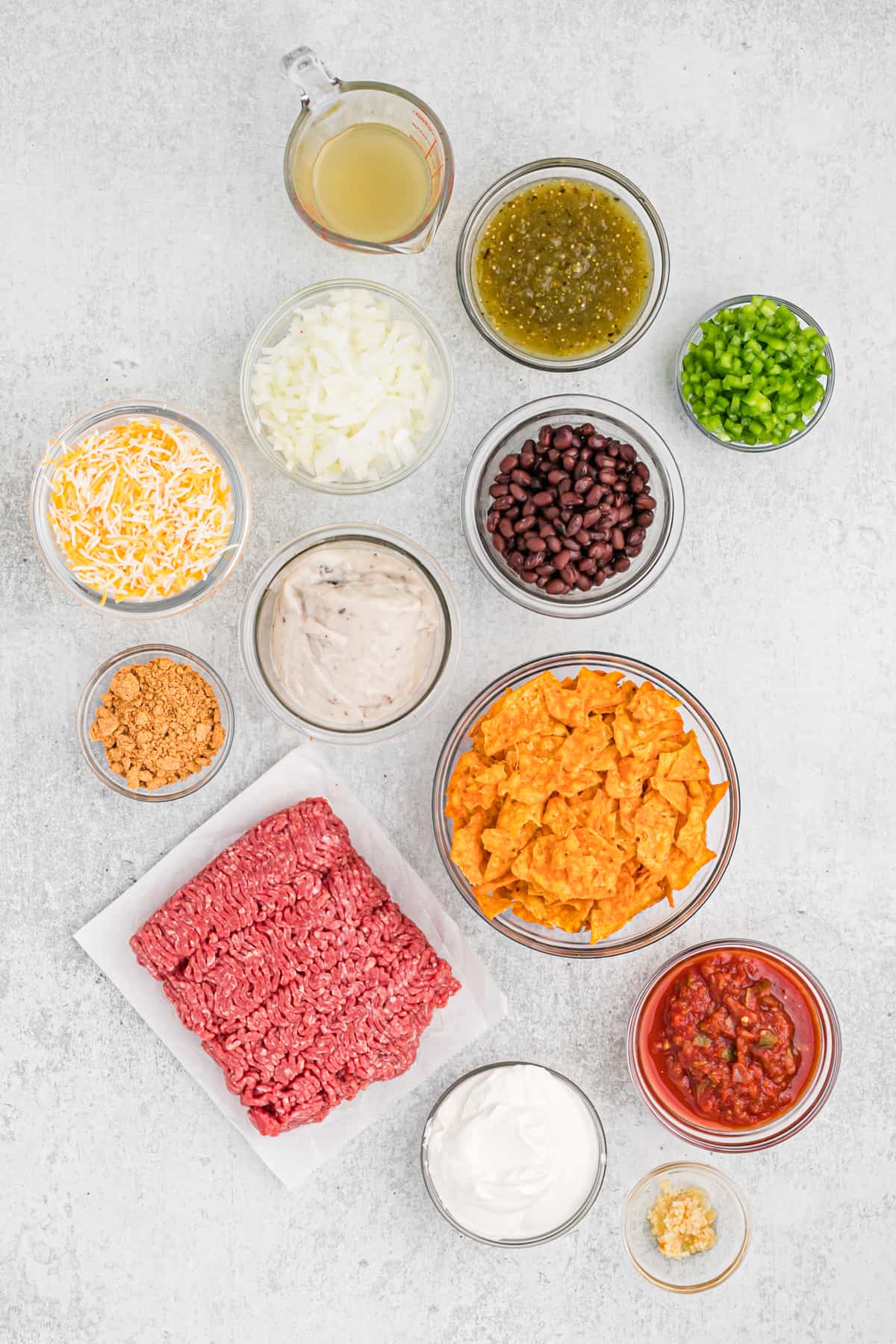 Ingredients in clear bowls to make a dorito casserole