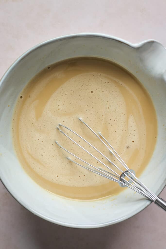 liquid mixture being whisked in a bowl