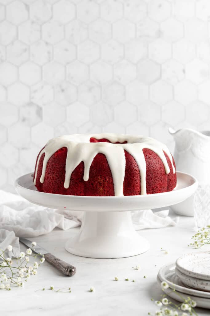 Iced red velvet bundt cake recipe on a cake pedestal