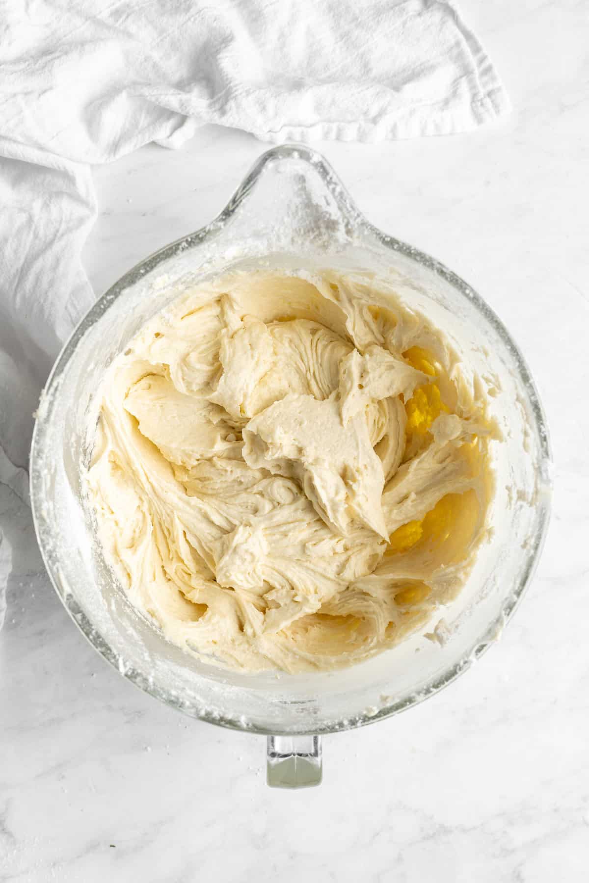 Dry ingredients added to stand mixer to mix a cake on white countertop