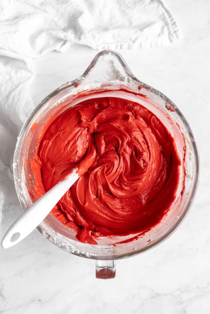 red food coloring and hot water are added and mixed in the stand mixer bowl