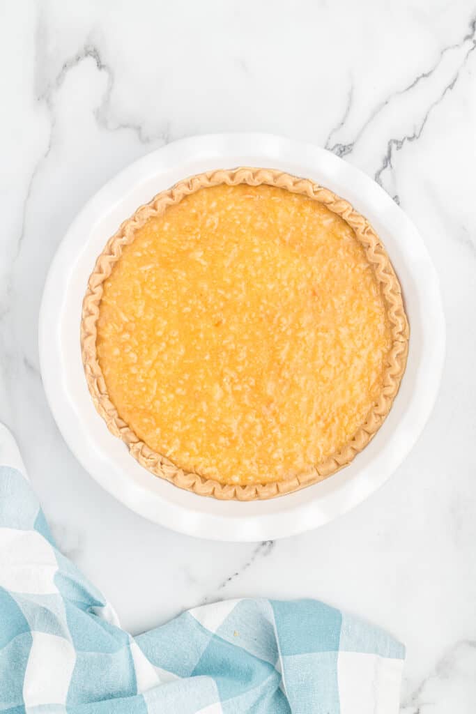 Unbaked coconut pie in a white pie plate.